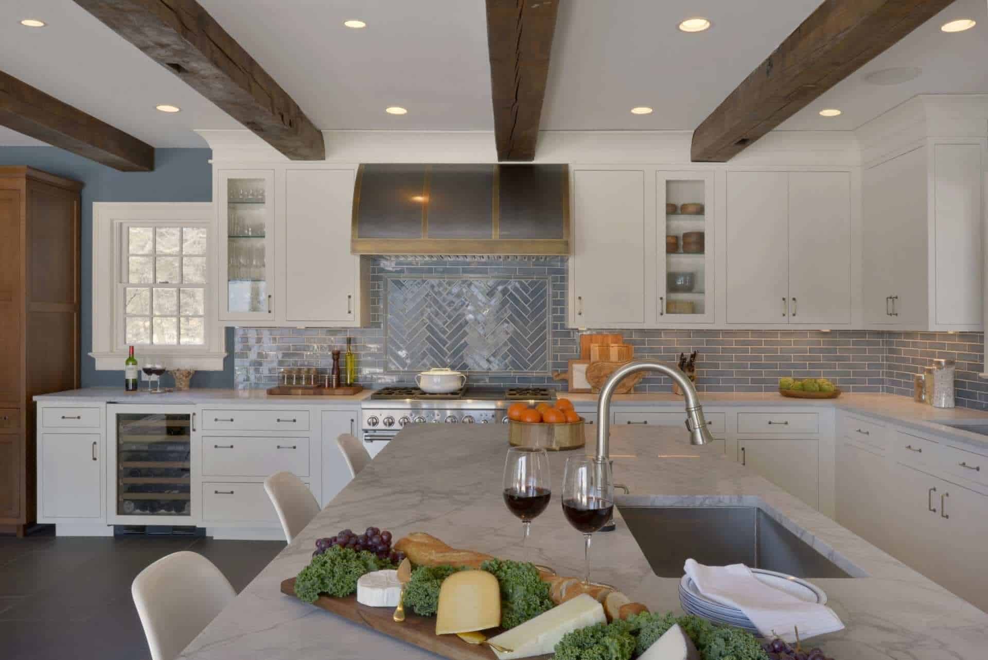 Transitional kitchen with exposed beams, white and oak Bilotta cabinets, ceramic tile backsplash and antique hood.