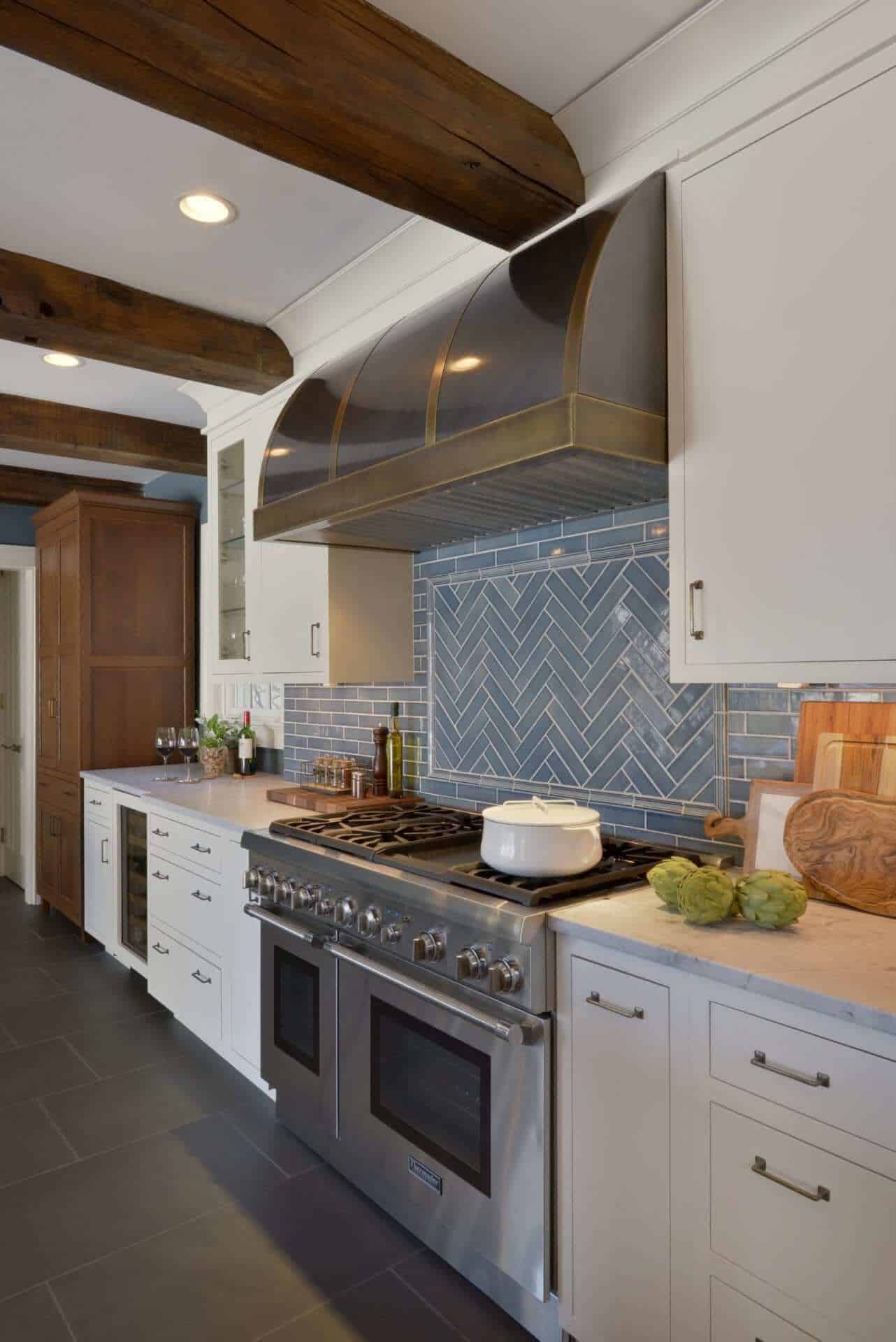 Kitchen features glazed blue tile backsplash, custom hood and white Bilotta cabinets with German antique glass inserts.