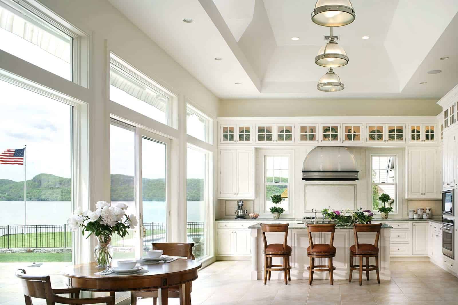 Sound view kitchen features tray ceiling and white raised panel Bilotta cabinetry, including lit, glass front top display cabinets.