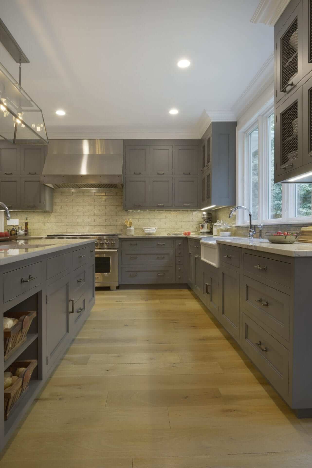 Country kitchen features wide plank flooring and grey Bilotta cabinetry with ample storage