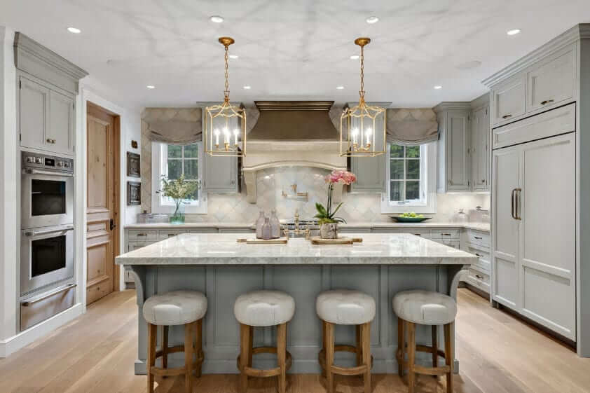 Dramatic kitchen features Lamp Room Gray Bilotta cabinetry, Pearlescent Clay tile harlequin pattern backsplash and an ornate custom hood.