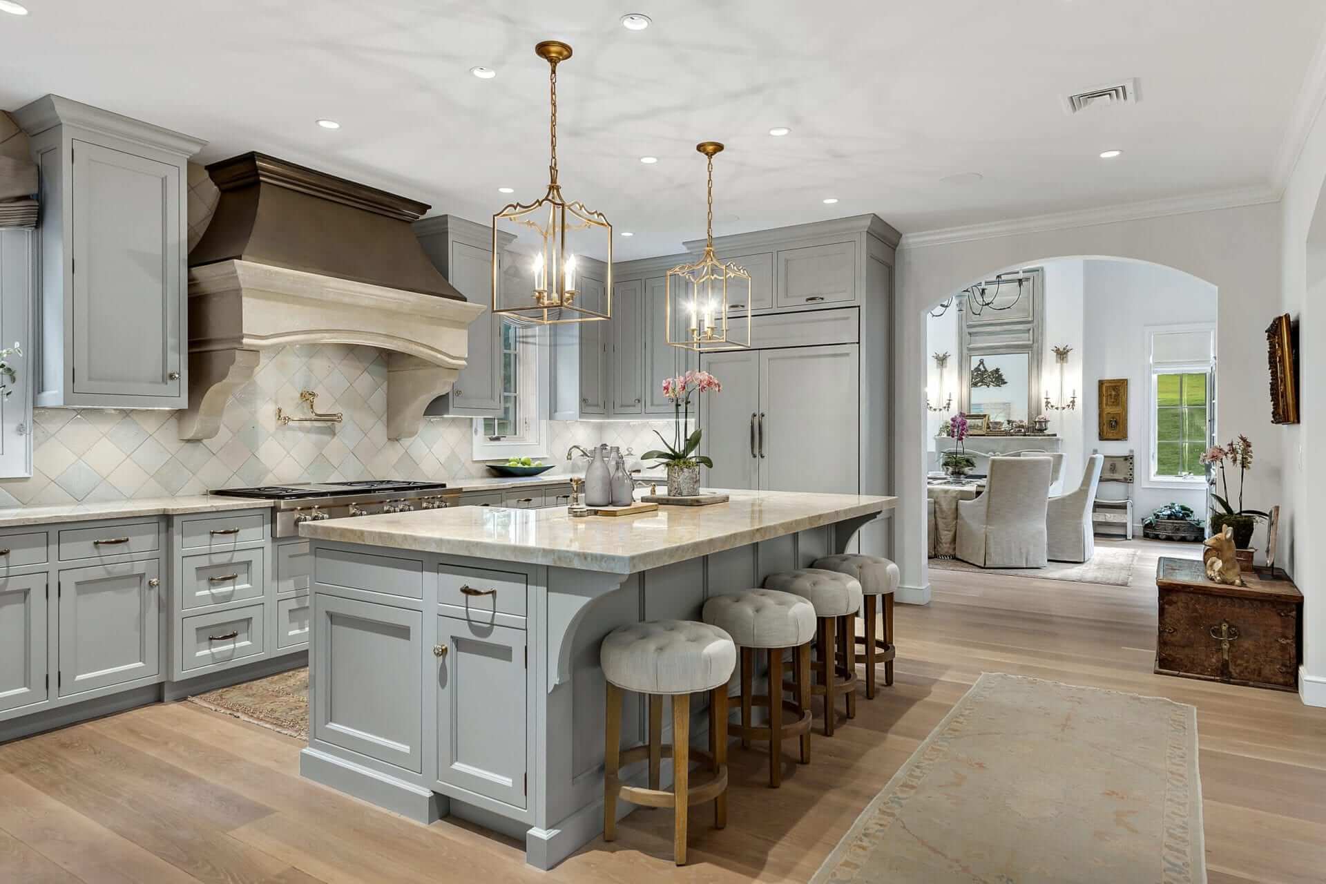 Dramatic kitchen with Lamp Room Gray Bilotta cabinets opens up into an dining room