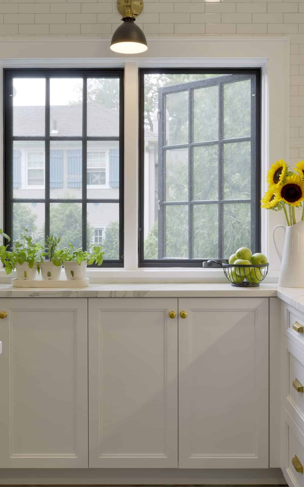 White kitchen with black window frames and white classic cabinetry.