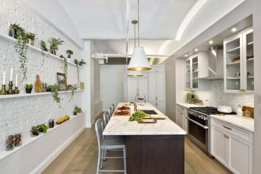 NYC loft kitchen features Bilotta marble topped walnut island and whitewashed brick walls with open shelving.