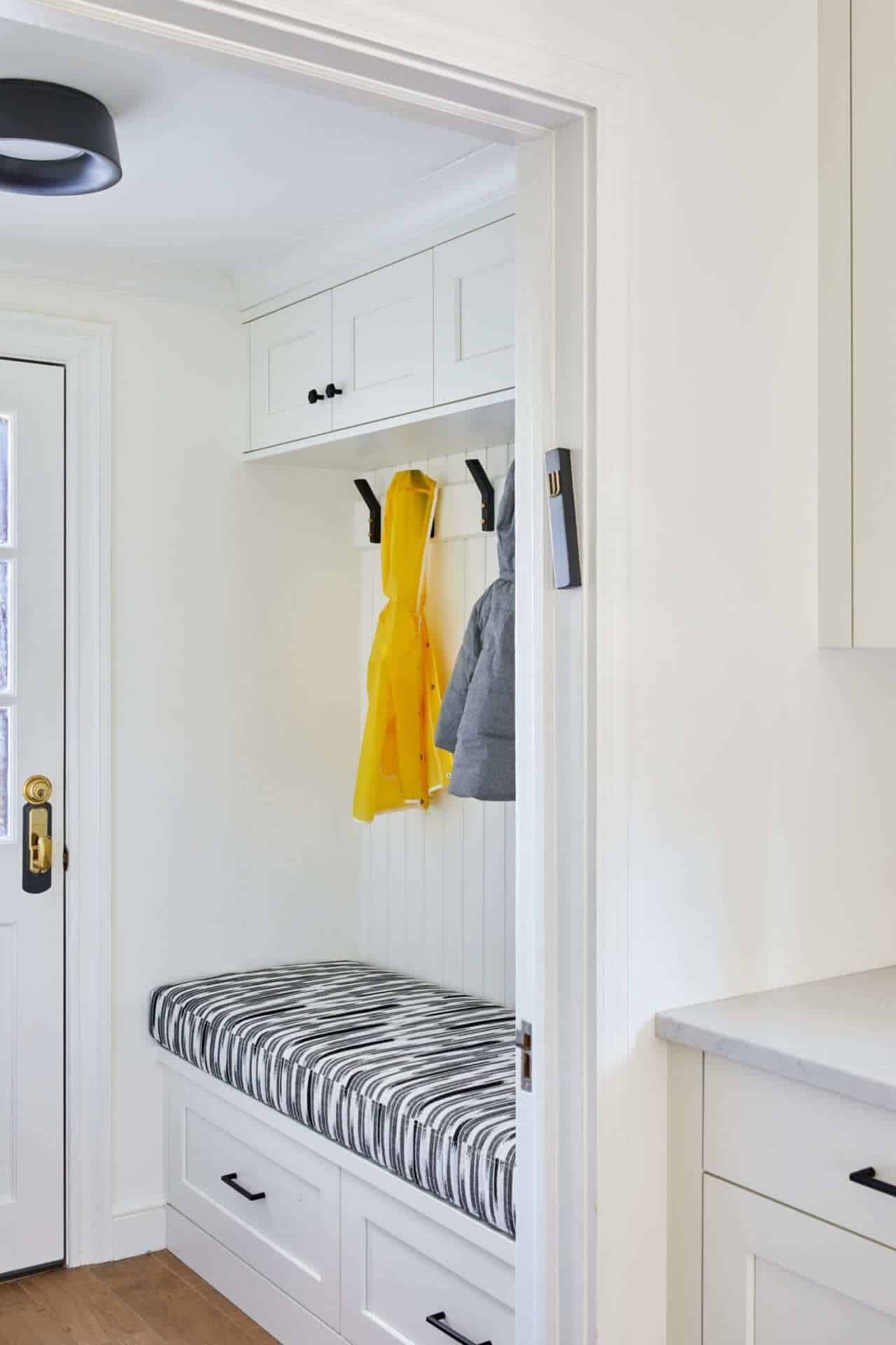 Mudroom with all white cabinets and bench