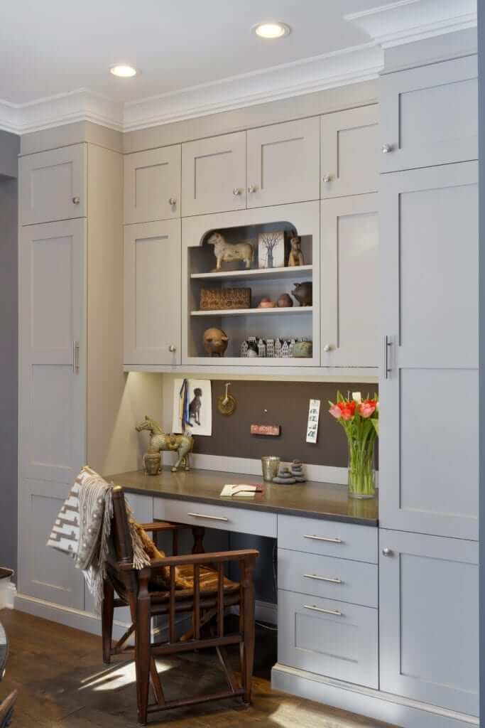Home office features custom light grey painted Bilotta Cabinetry desk and custom built-in shelving. 