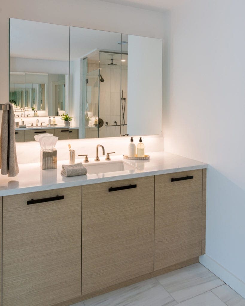 Contemporary spa bathroom features a large bay of windows, pale oak cabinetry, light dolomite tiles and soaking tub.