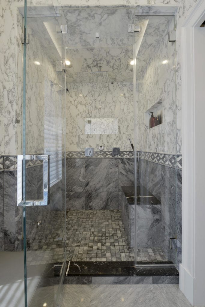 Shower with calcutta and gray marble tile in luxury bathroom.