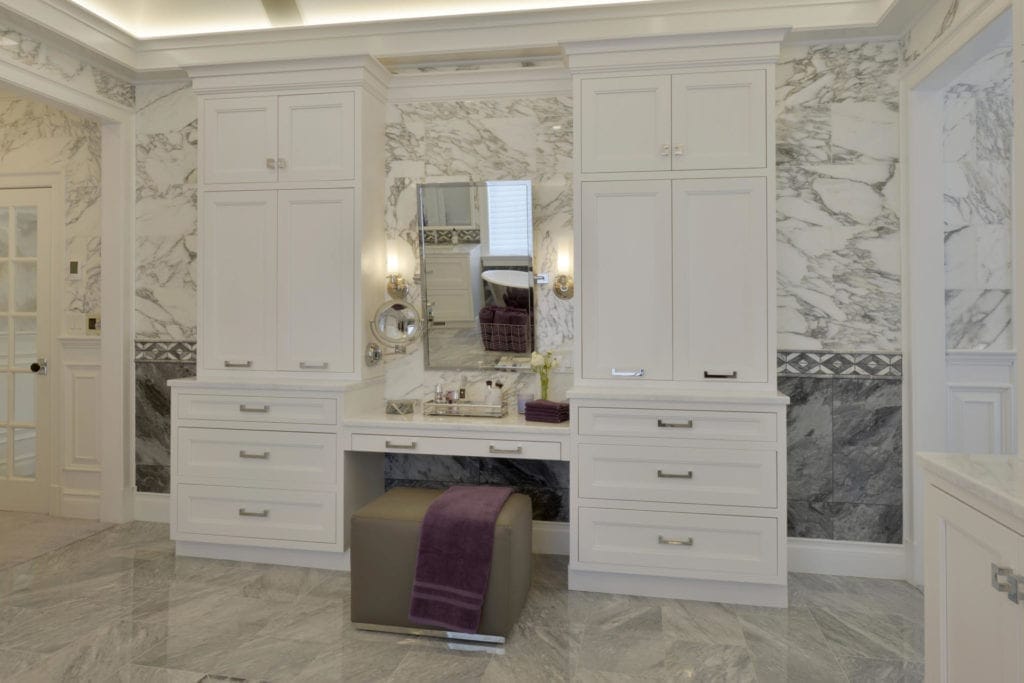 Luxury bathroom features custom white Bilotta cabinetry with polished nickel hardware and Calcutta and gray marble backsplash and flooring.