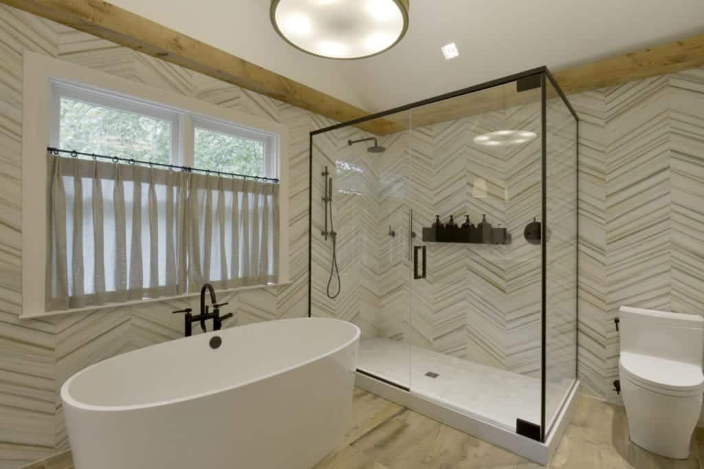 Classic bathroom features Chevron patterned walls and backsplash and Caesarstone-topped Smoky Oak Artcraft cabinetry.