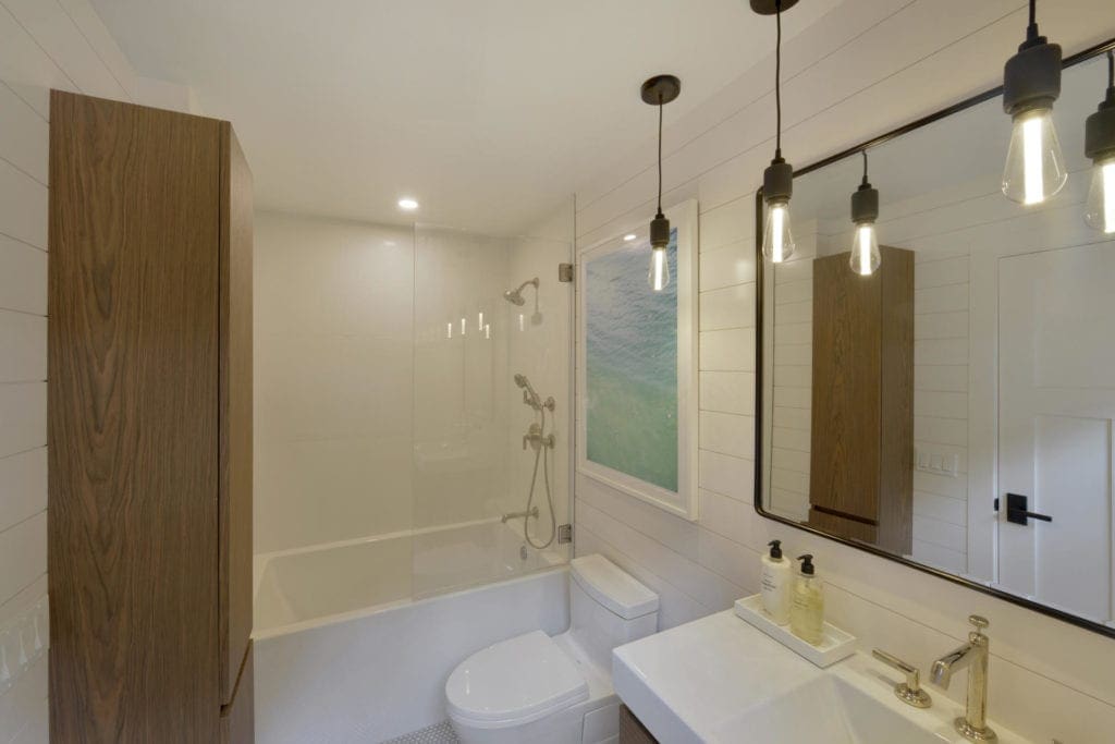 Contemporary bathroom with walnut linen cabinet and soaking tub.