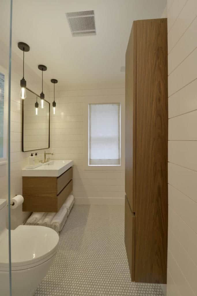 Contemporary bathroom with walnut linen cabinet and floating vanity and ship lap walls.