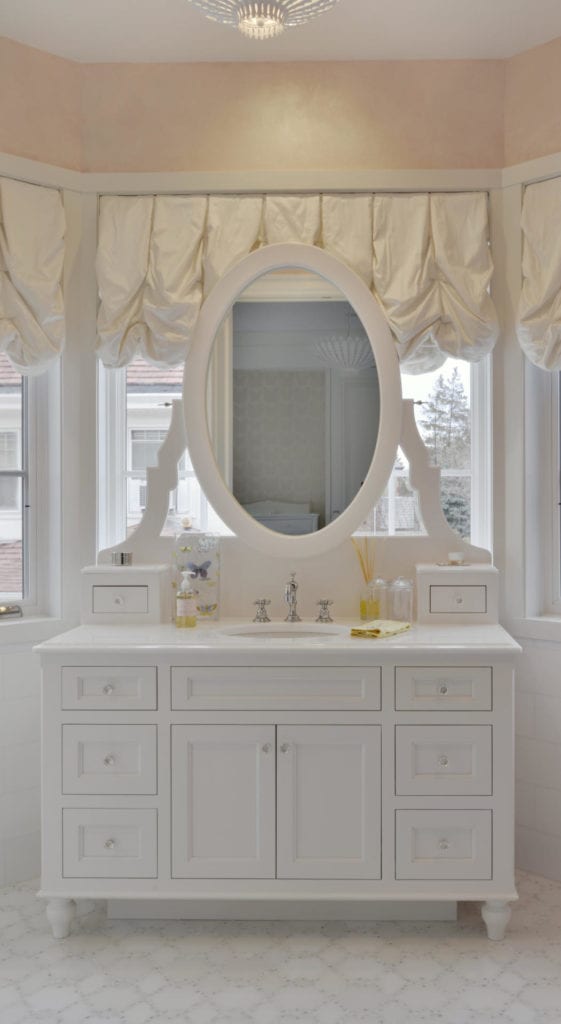 Little girl's bathroom vanity with oval mirror.