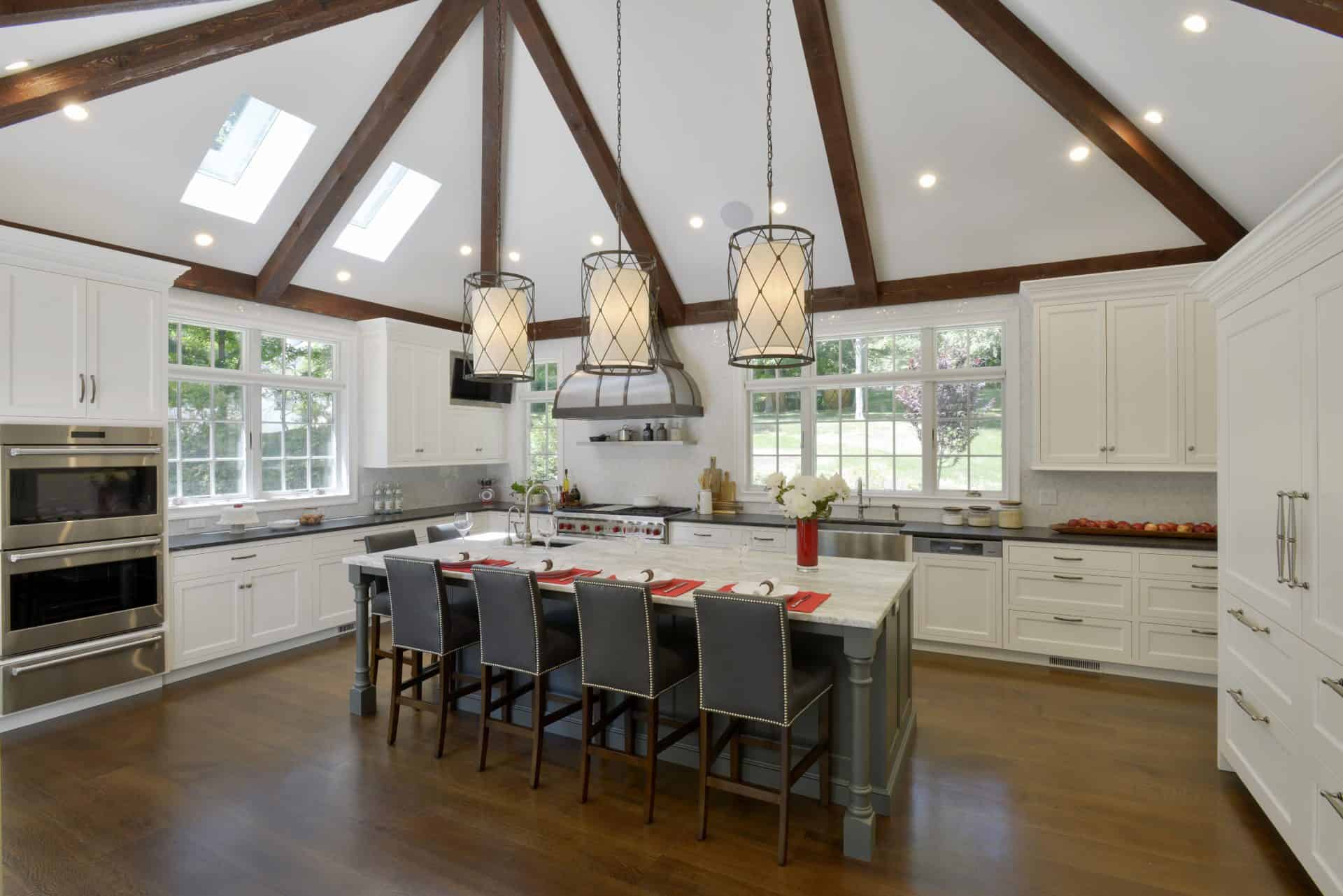 Classic kitchen in Somers NY features catherdral ceiling with exposed beams and white painted Bilotta cabinetry.
