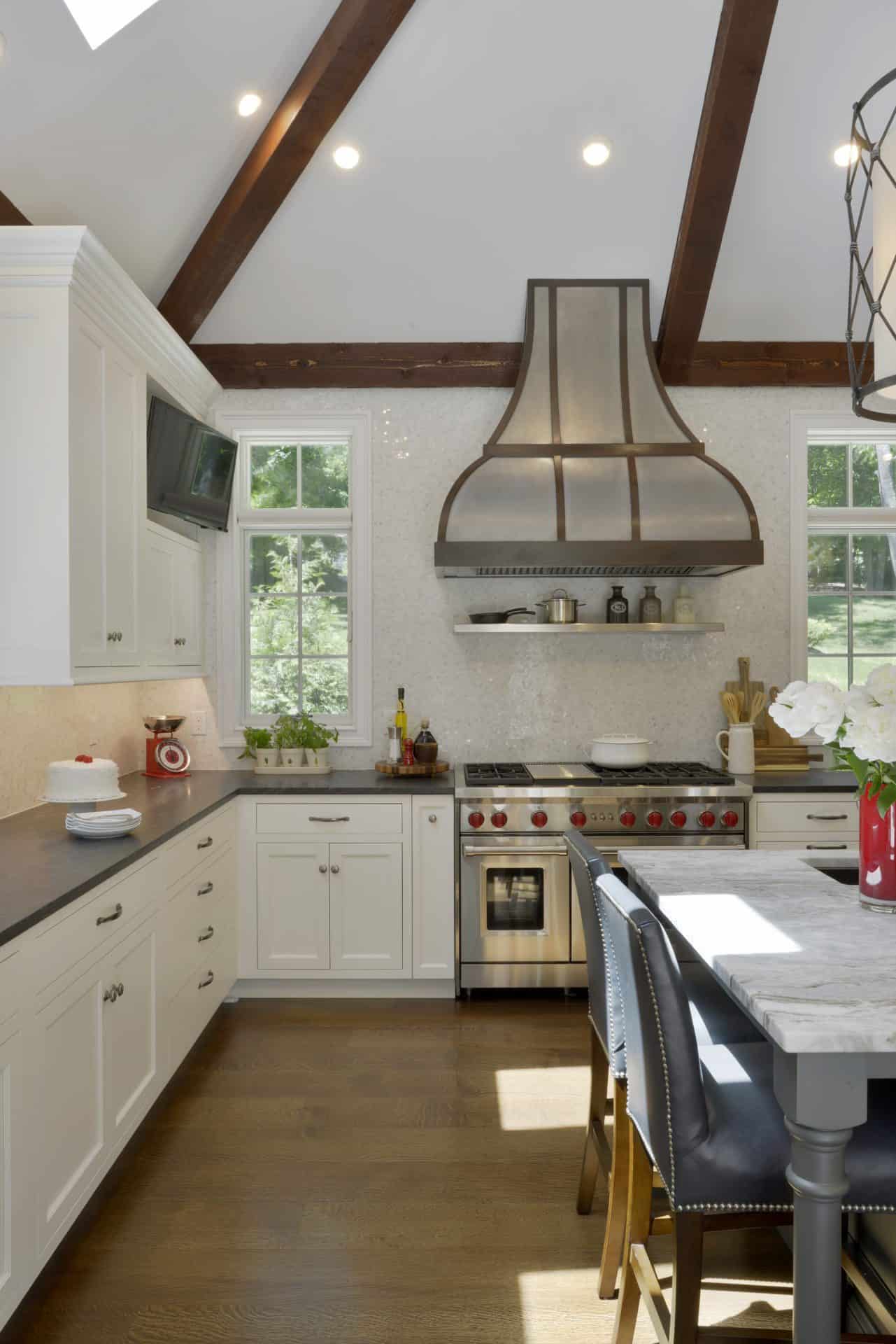 Custom somers NY kitchen features white painted Bilotta cabinets, gray quartz counters and custom range hood.