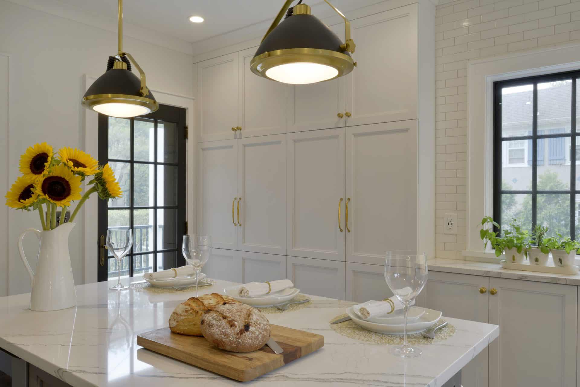 Mount Kisco Kitchen features white NAC cabinets, black window frames and ba\lack and brass accents.