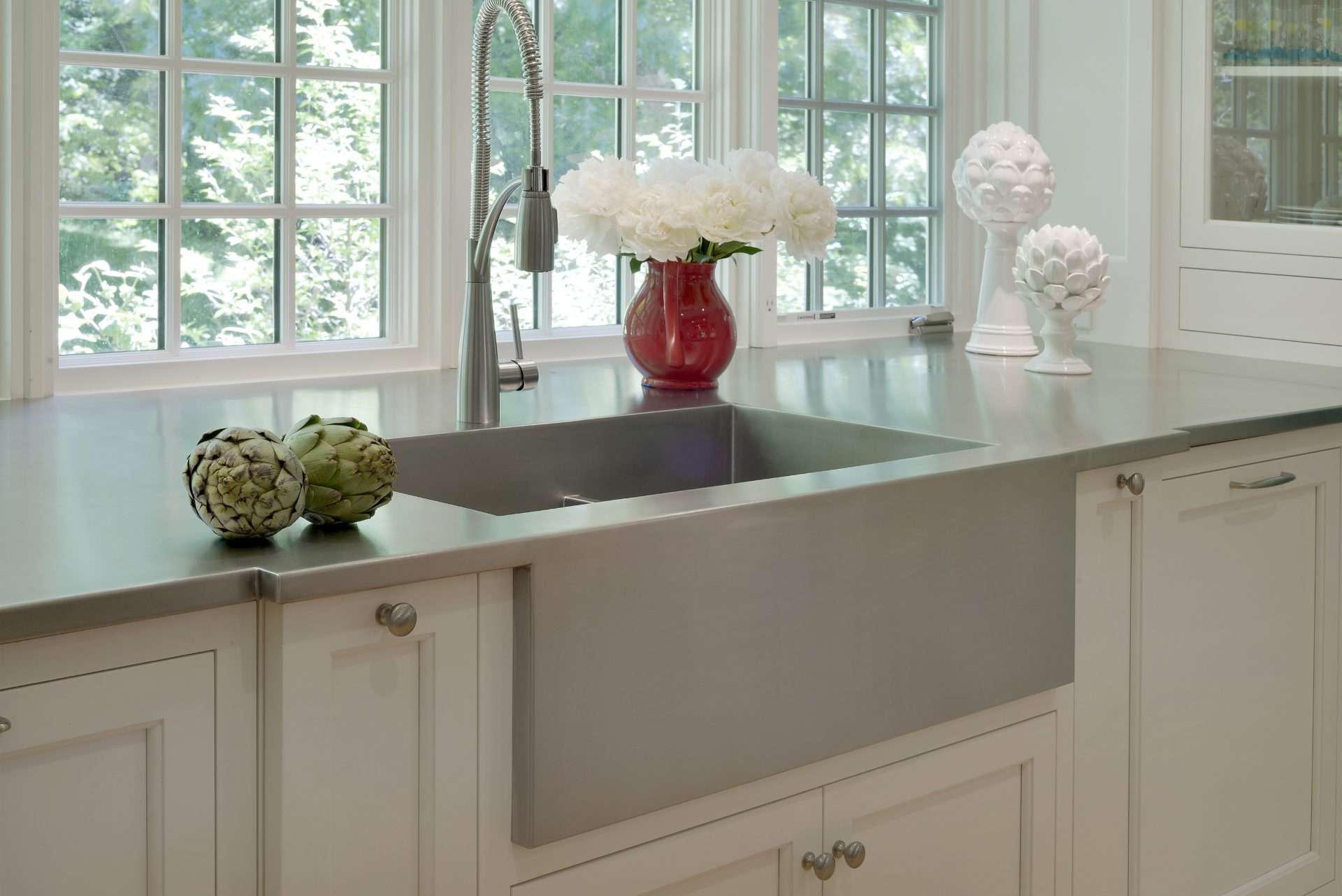 Waccabuc kitchen features  white Bilotta cabinetry and stainless countertop.