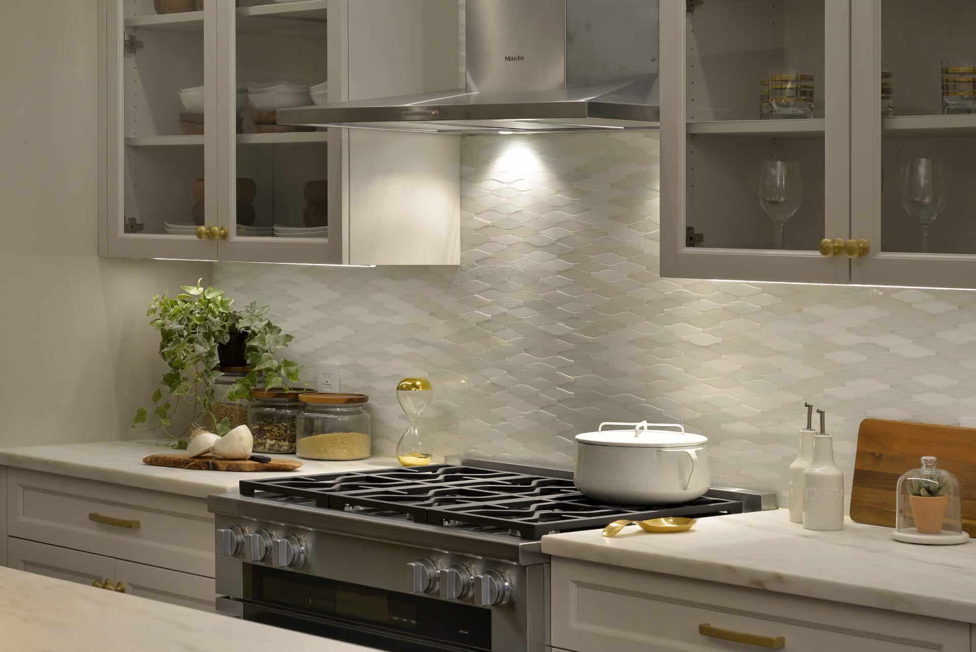 SoNo loft kitchen features Bilotta cabinets in Balboa Mist and Jazz Glass mosaic backsplash.