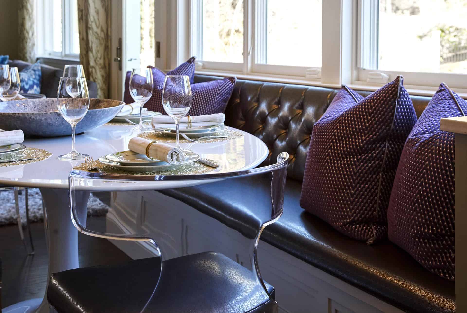 Banquette with Purple Leather Cushions and Purple Pillows and Lucite Chairs