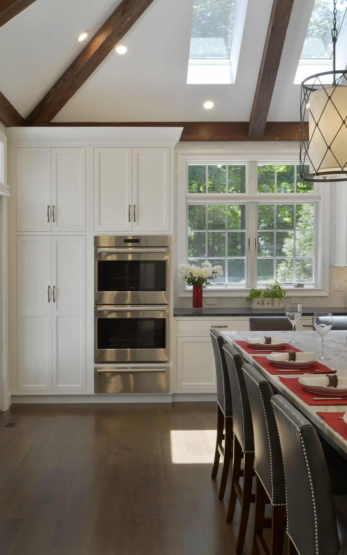 Classic kitchen features white Bilotta custom cabinets, inset oven, custom island and large windows.