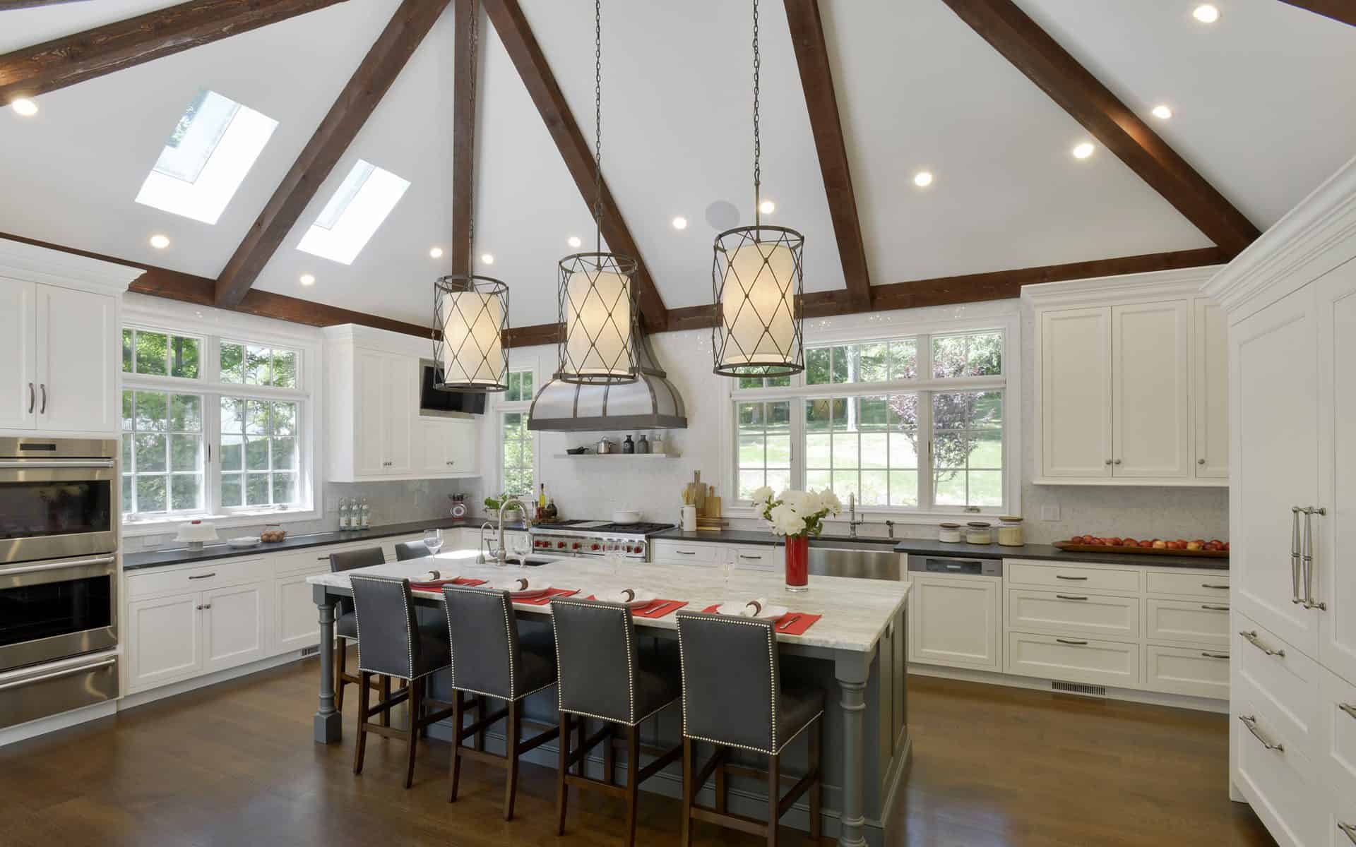 White classic kitchen features dark wood beams, custom marble-topped island, skylights and Bilotta cabinetry.
