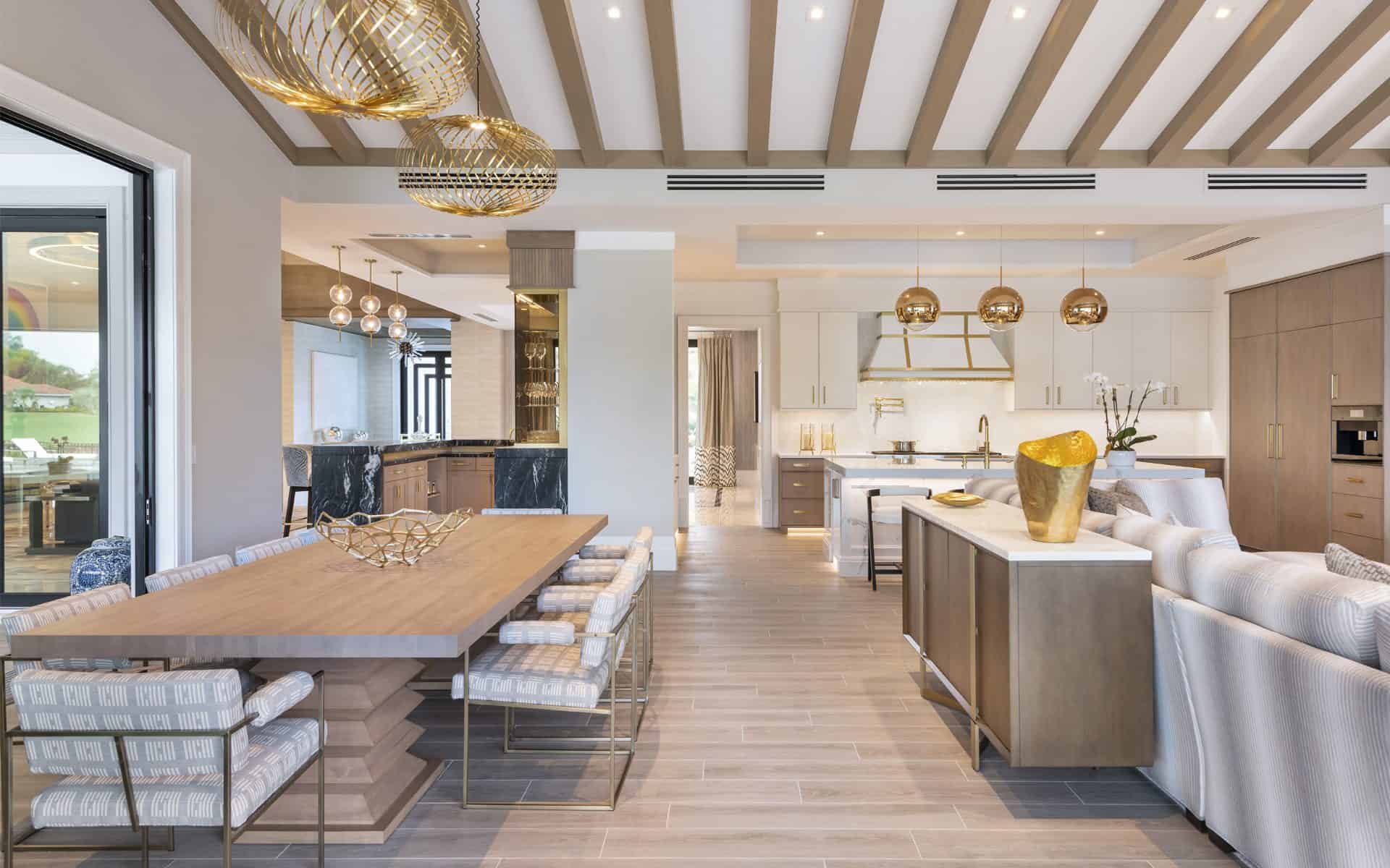 Modern eating area features modern low-profile furniture, contemporary gold accents and white custom kitchen.