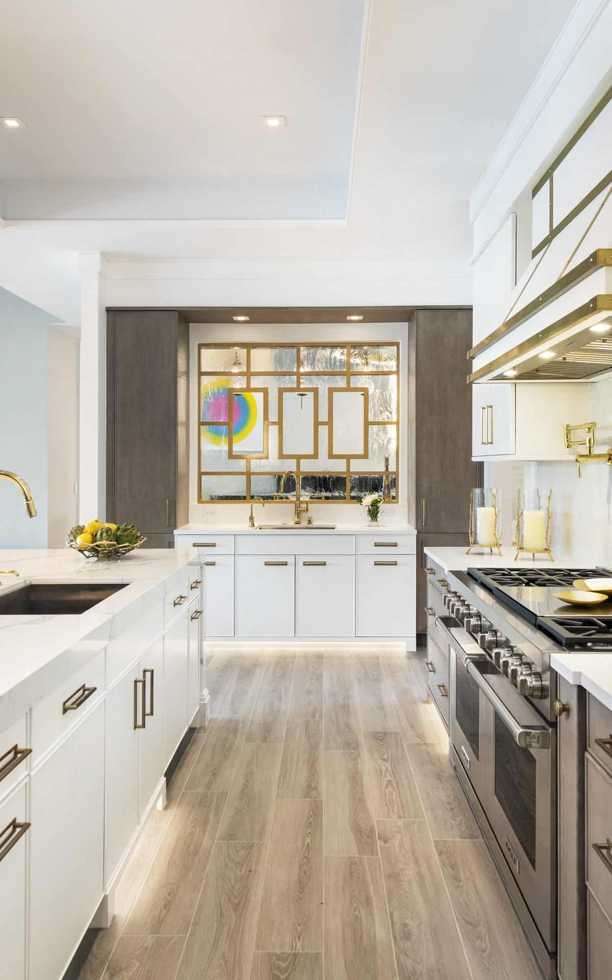 Classic kitchen features white custom cabinetry and dramatic mirrored bar with gold contemporary design.