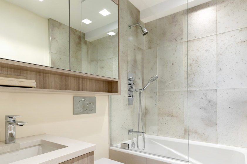 Custom bathroom features Bilotta horizontal-grained cabinetry and modern accessories and fixtures.