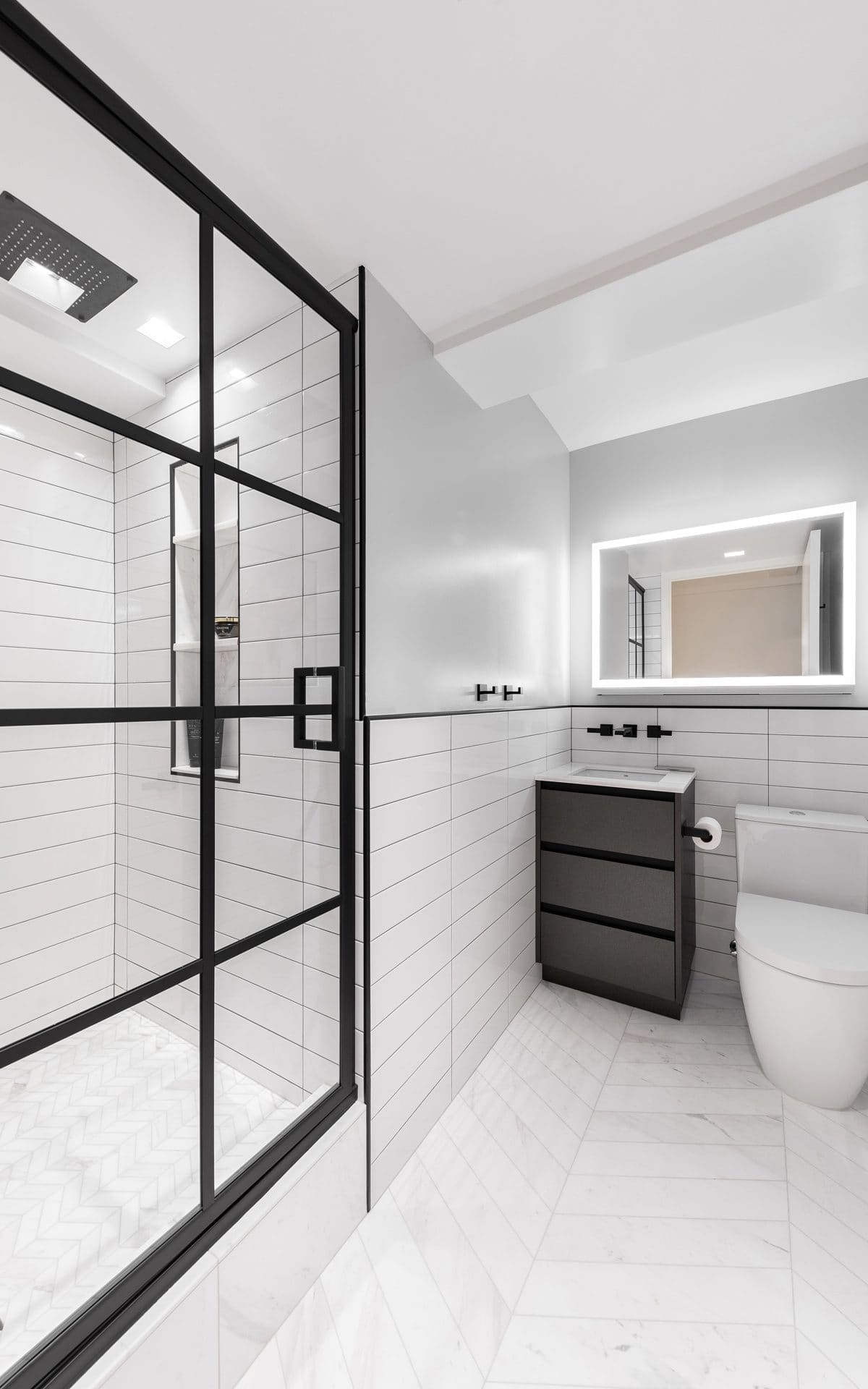 Ultra-modern bathroom features black-paned shower, white floor and backsplash tiles, and white modern accents.