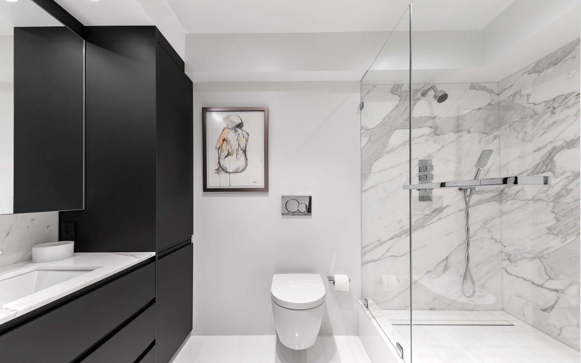 Bathroom features Bilotta black handle-less caninetry, marbled shower and modern bathroom appliances and fixtures.