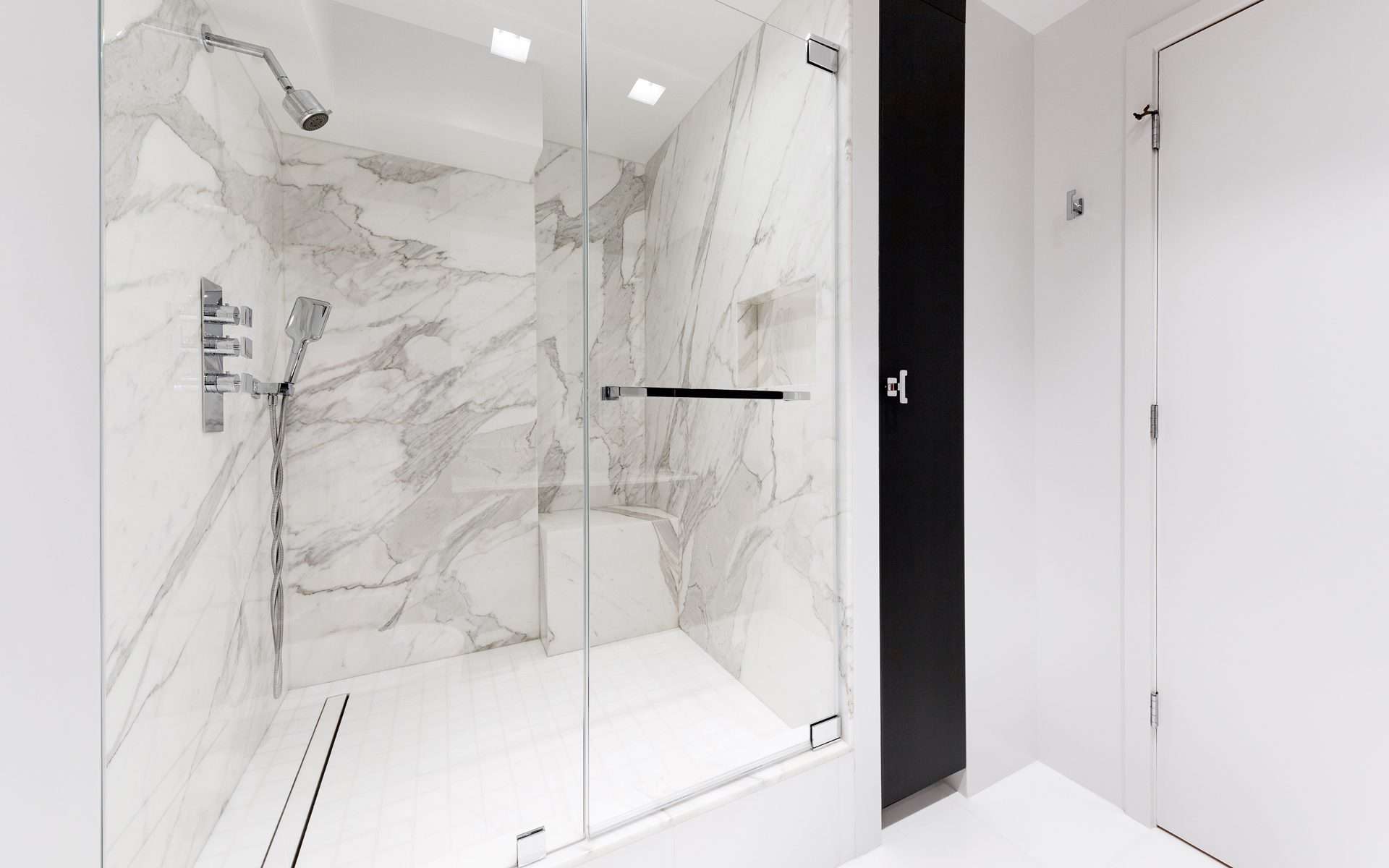 Bilotta custom bathroom features expansive white and gray marble shower with modern fixtures.