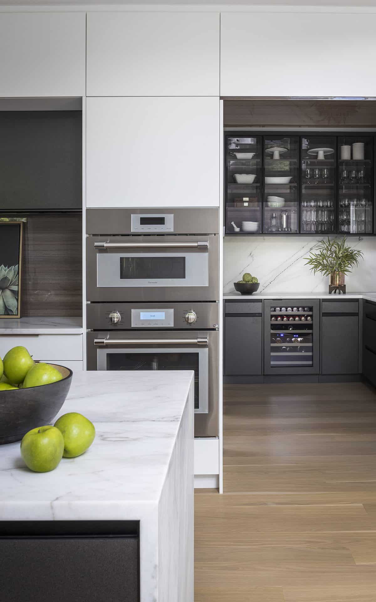 Custom kitchen features modern custom island, custom wetbar and stainless modern oven.
