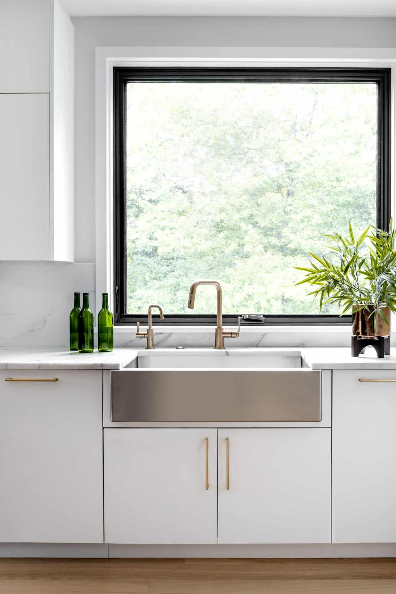 Modern kitchen with custom white Bilotta cabinetry and stainless steel farmhouse sink.