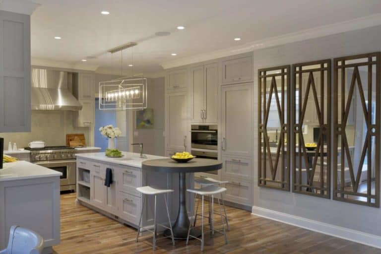 New York custom kitchen with plank wood flooring, white cabinets, and stainless steel appliances
