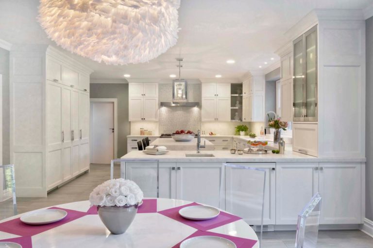 white classic u-shaped kitchen with pops of pink in the dining area