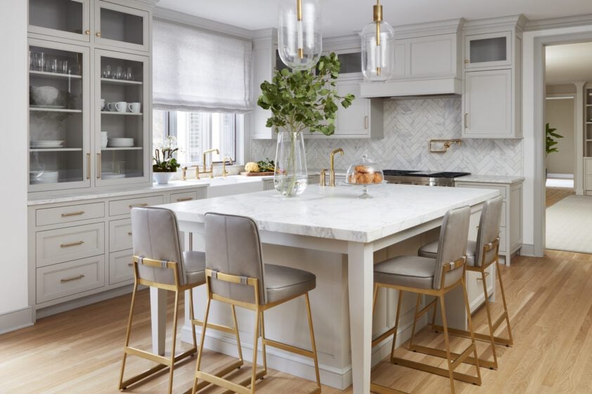 Classic kitchen with Bilotta Collection cabinetry in Sherwin Williams Repose Grey, with marble island and counter tops and herringbone marble backsplash