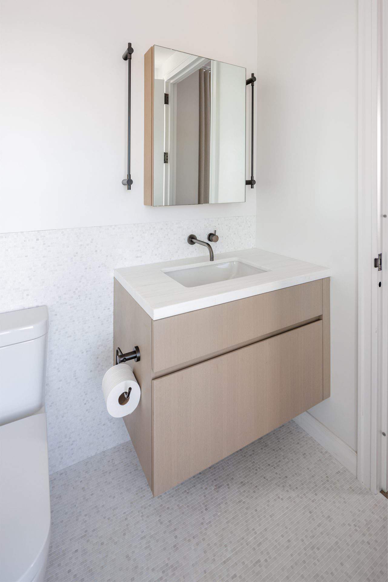 Bilotta vanity in Rift Cut White Oak, Natural Stain, White mosaic Artist Tile on floor and wall, with mirror.