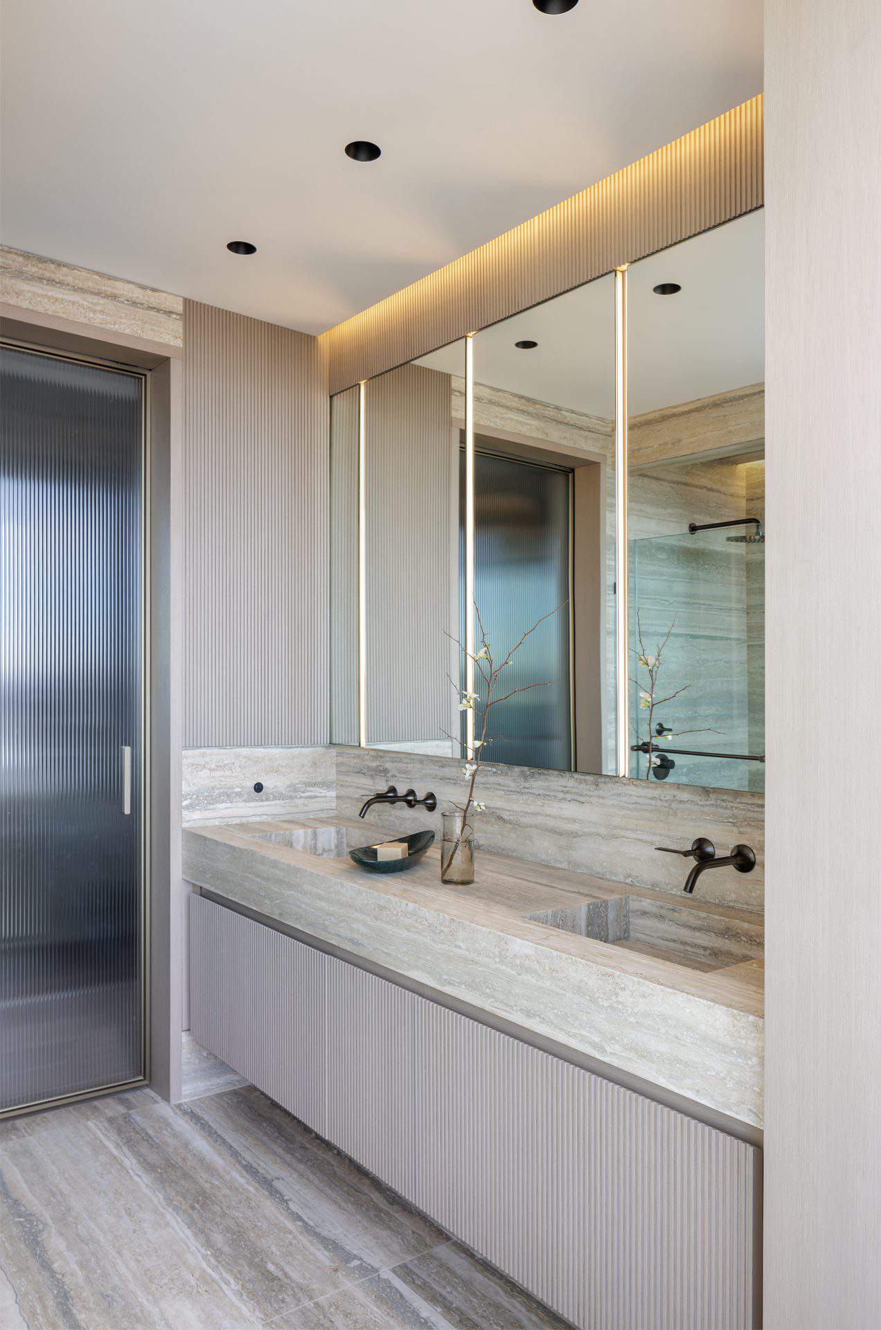 Earth-toned bathroom with Bilotta double sink vanity, pocket glass door