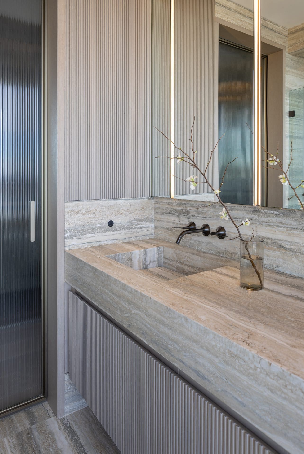 Earth-toned bathroom with Bilotta vanity, pocket glass door