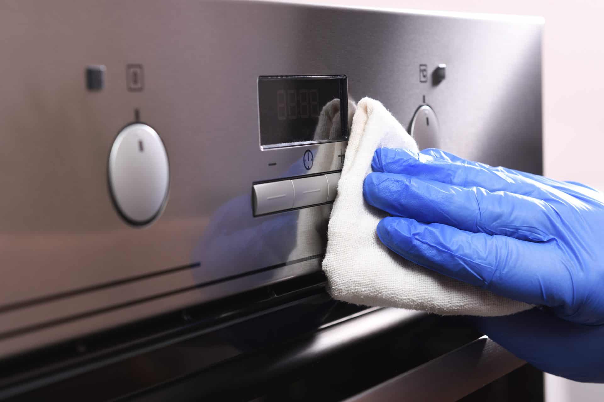 Man Polishing the Front of an Oven